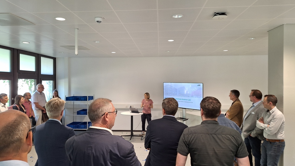 Gruppe von Menschen bei einer Präsentation im KIT Artificial Intelligence and Data Science Lab.